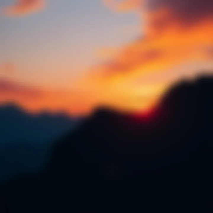 A stunning sunset with vibrant colors behind tall mountains and a clear sky