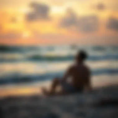 A person sitting on the beach, looking peaceful while watching the waves at sunset.